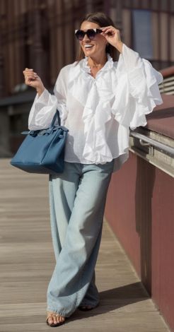 White blouse-shirt made of light fabric with frills and frog