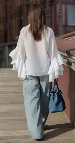 White blouse-shirt made of light fabric with frills and frog
