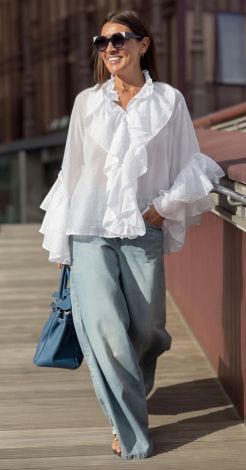 White blouse-shirt made of light fabric with frills and frog